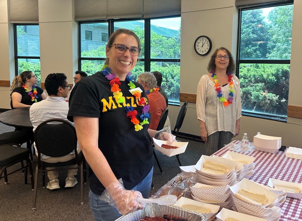 Staff Council volunteers serve hot dogs.
