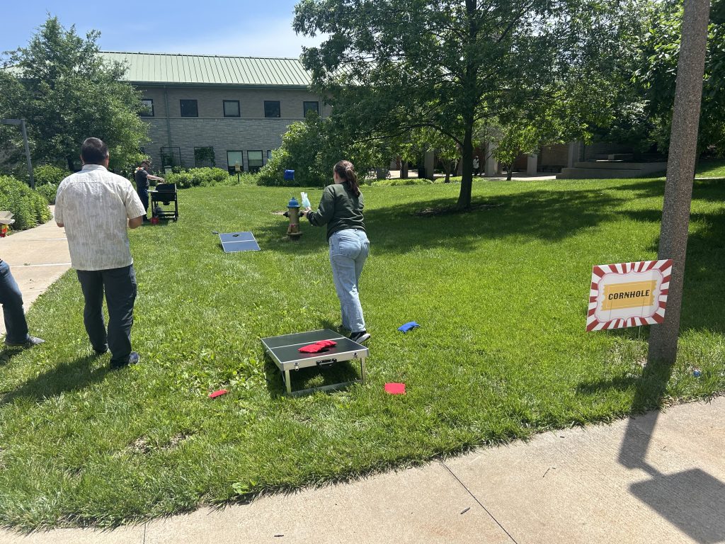 An attendee throws a bag in cornhole.