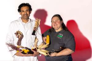 Two people holding corn