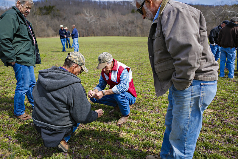 Several men standing together in a field.