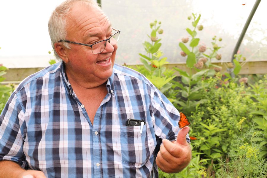 Tim Reinbott smiling with a butterfly on his hand.