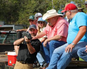 A presenter demonstrates a handheld remote controller to a group of people.