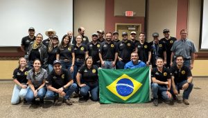 A group of people pose with the Brazil flag.
