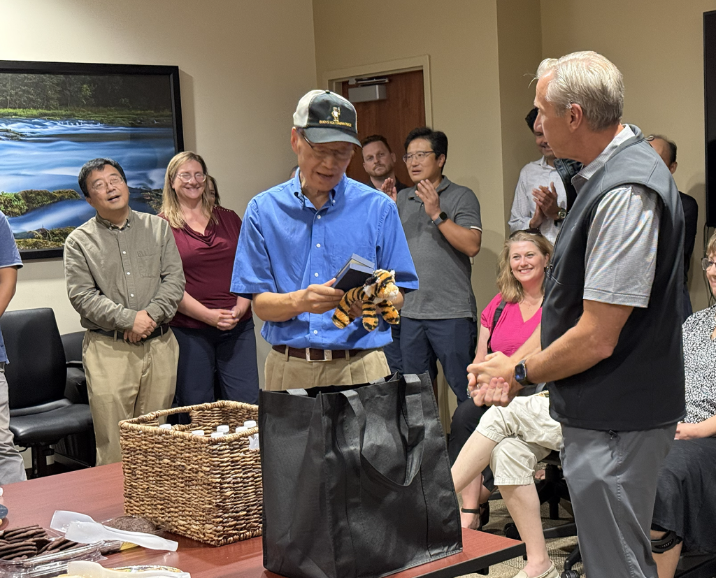Jinglu Tan opens a gift from Vice Chancellor and Dean Chris Daubert at his retirement celebration Wednesday, Aug. 26. Dr. Tan
