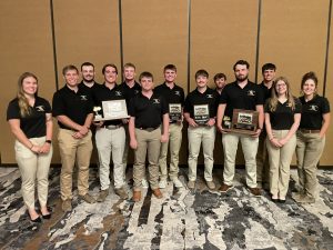 2025-26 Torq'N Tigers members stand and hold awards.
