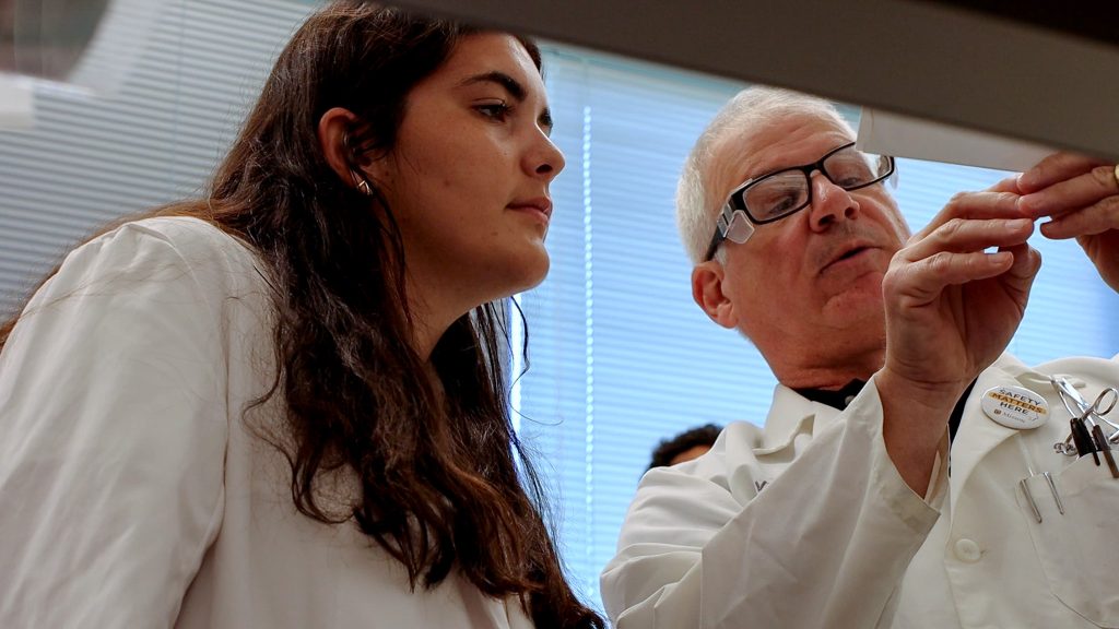 Thomas Reilly shows a Life Sciences Quest attendee something in a biochemistry lab.