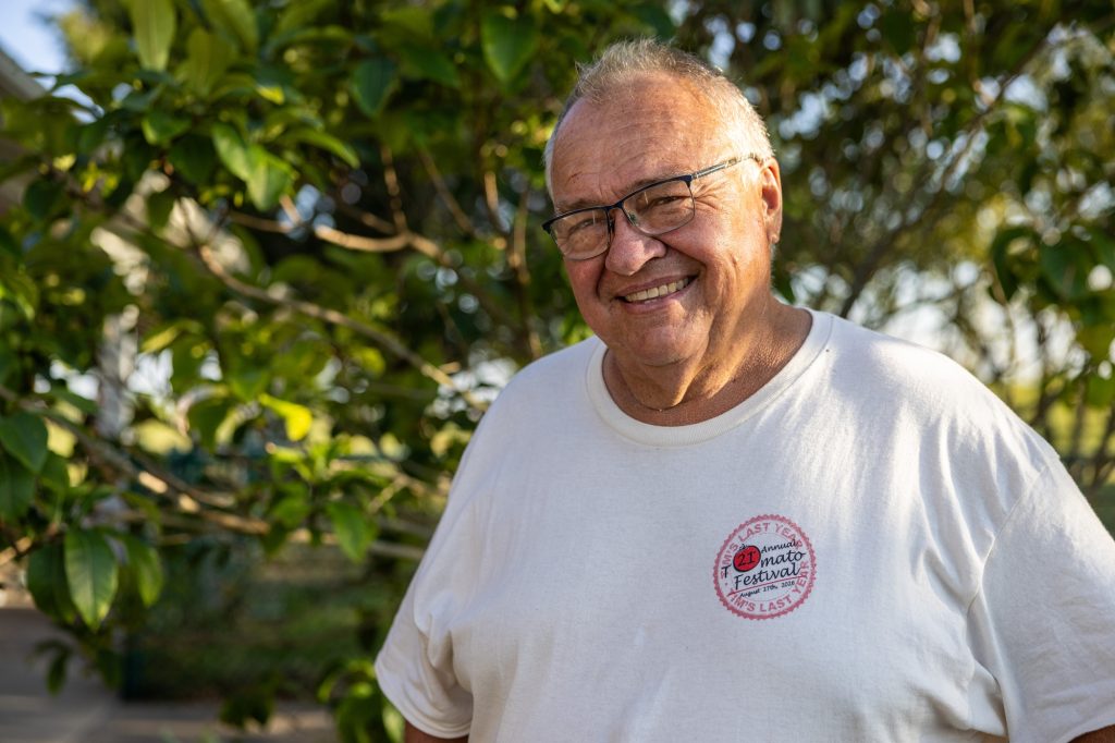 Tim Reinbott smiling in front of a tree.