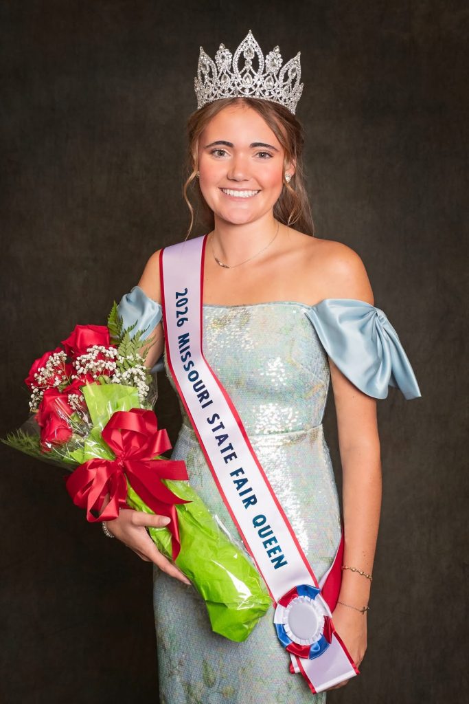 Tess Bauer smiles wearing her evening gown, crown and sash as 2026 Missouri State Fair Queen and holds a bouquet of roses.
