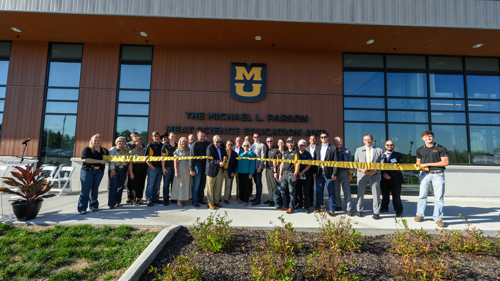 Former Gov. Parson cuts ribbon at Meat Science Lab, as a crowd looks on.