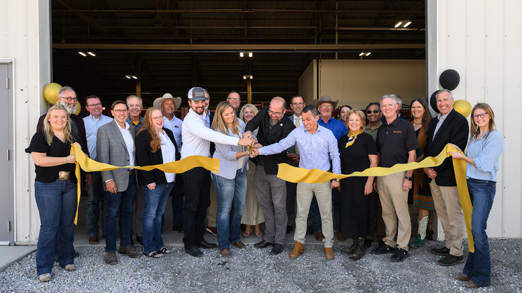 Smiling group cuts ribbon at NCARG facility.