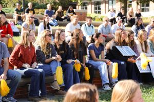 Students sit on Carnahan Quad and smile.