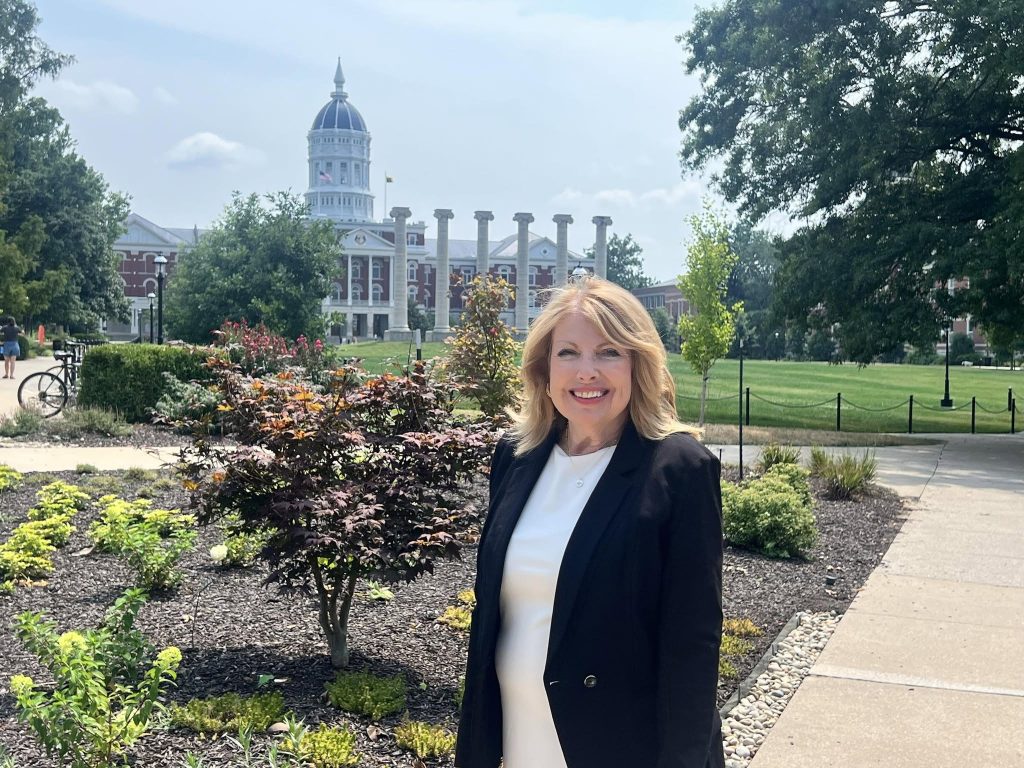Linda Geist poses on campus, with Jesse Hall and the columns in the background.