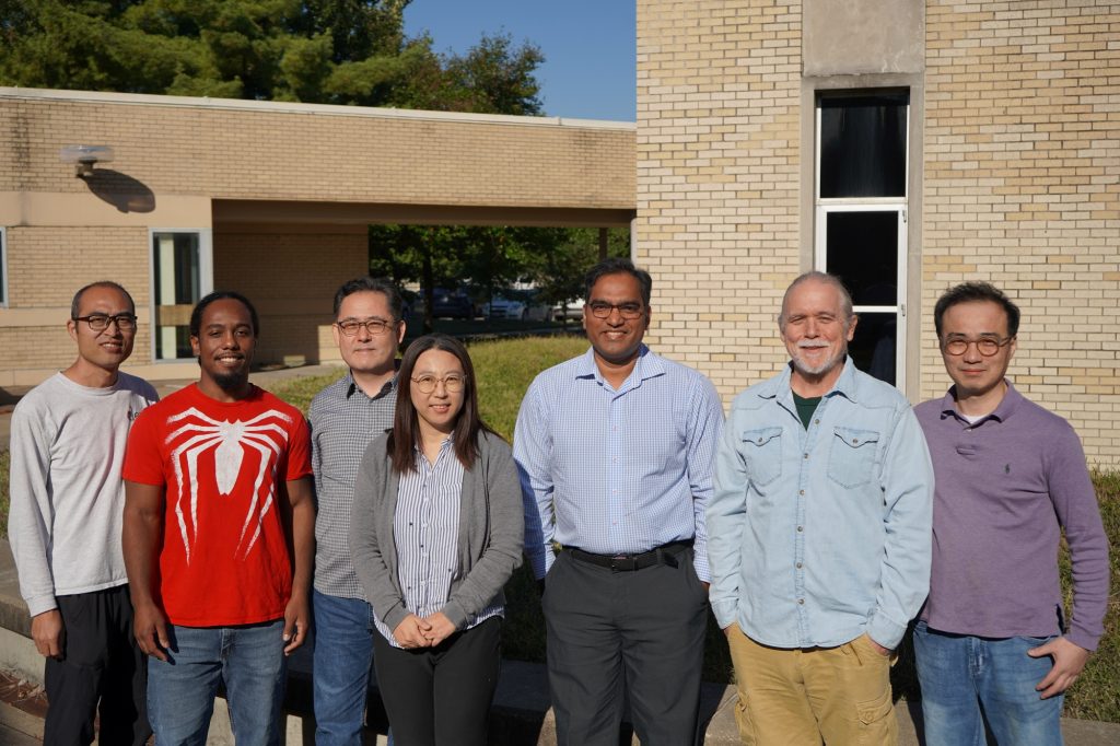 Several researchers pose outside.