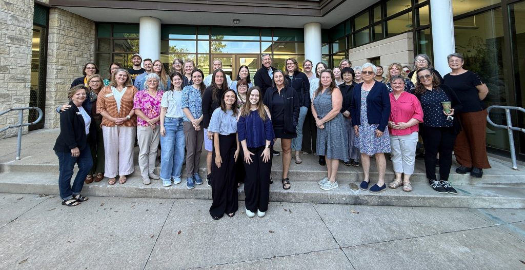 A group of CAFNR staff members stand in the courtyard of the Agriculture Building and pose for a photo.